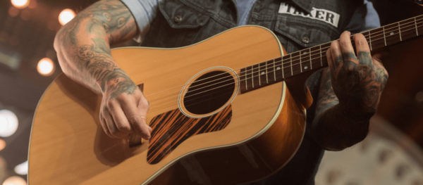 Man playing one of several acoustic guitar body shapes
