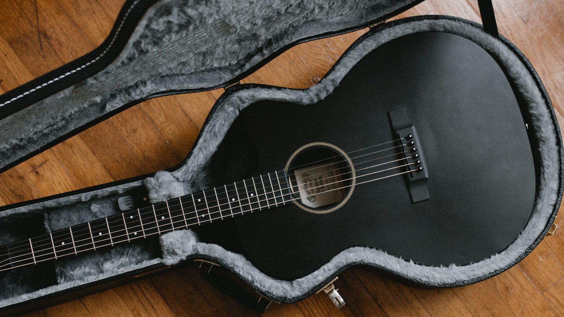 A an acoustic guitar plays in an open case, potentially in DADGAD tuning.