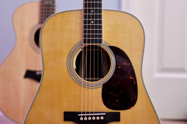 Close-up photo of a modern Martin guitar in a room.