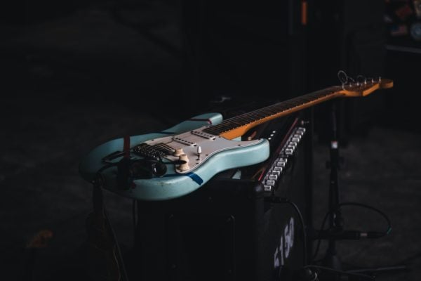 Photo of a light blue Stratocaster sitting on an amp.