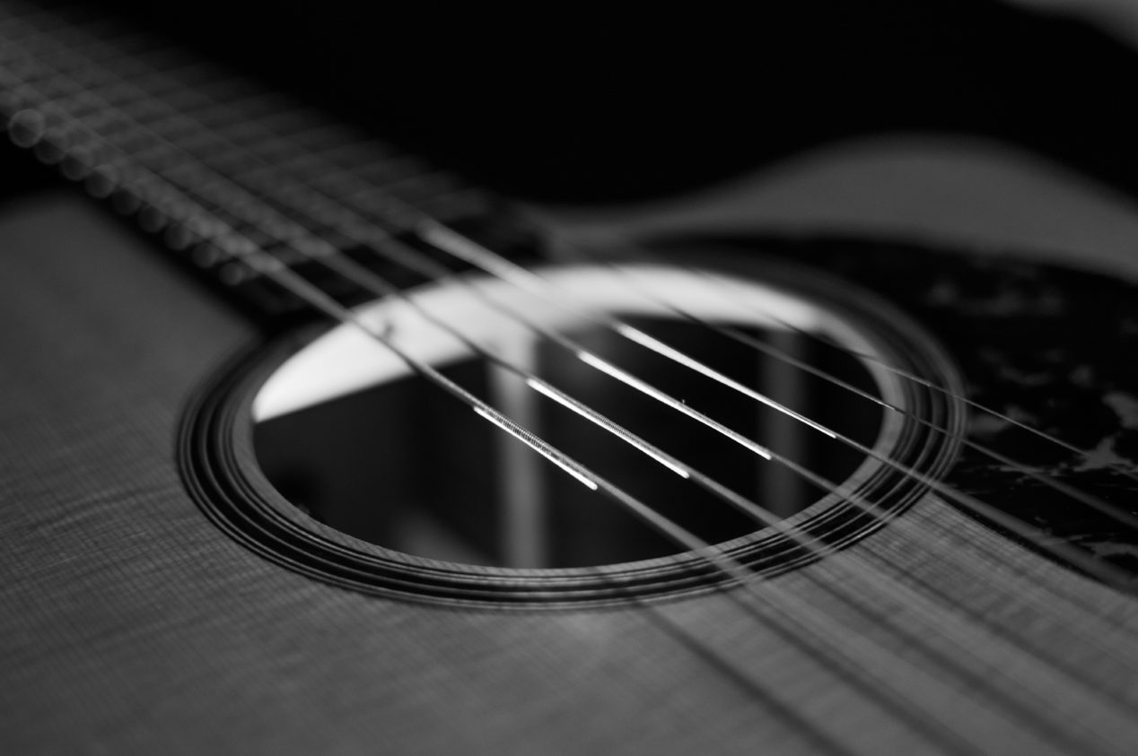 Black and white photo of an acoustic guitar's sound hole.