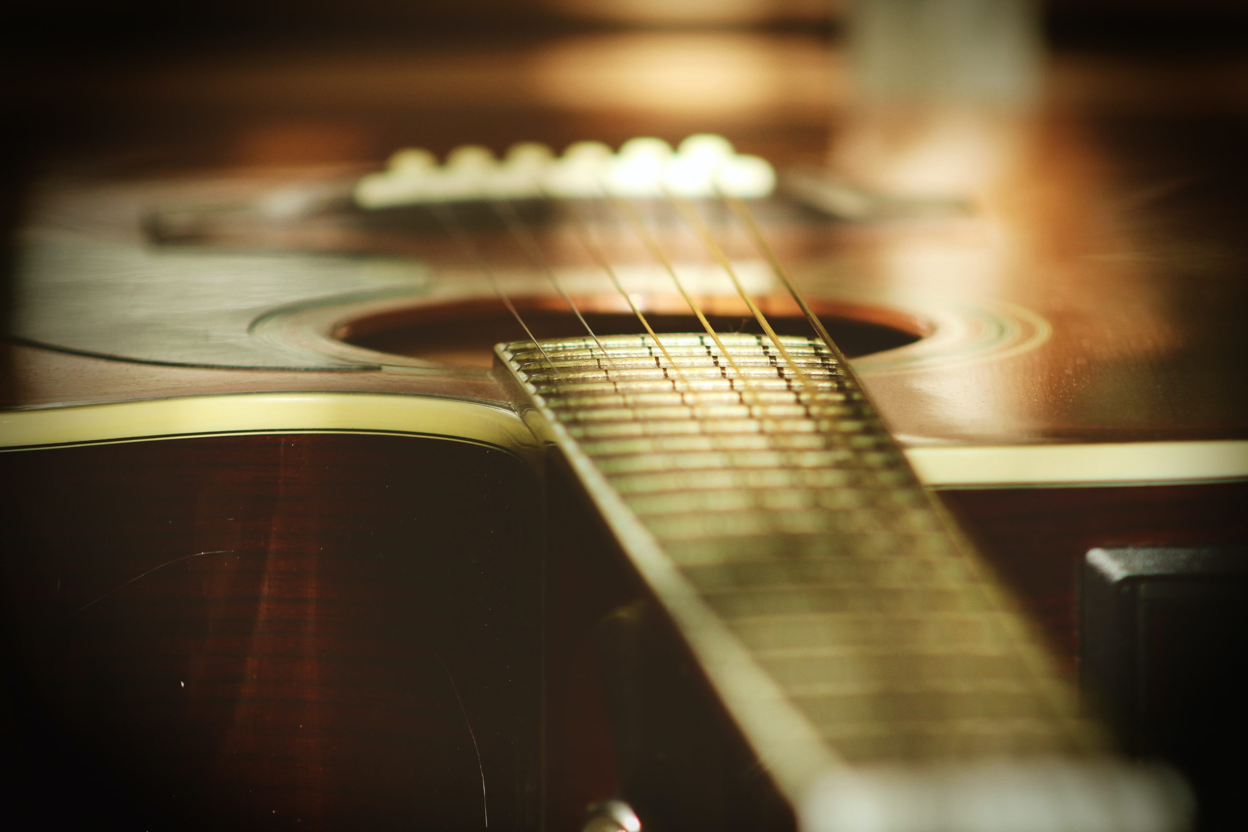 Close up photo of an acoustic guitar, looking down from the neck.