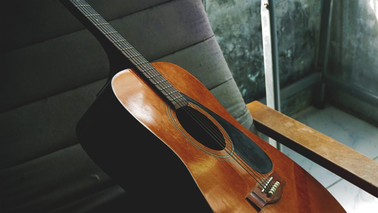Photo of a vintage dreadnought acoustic sitting on a chair.