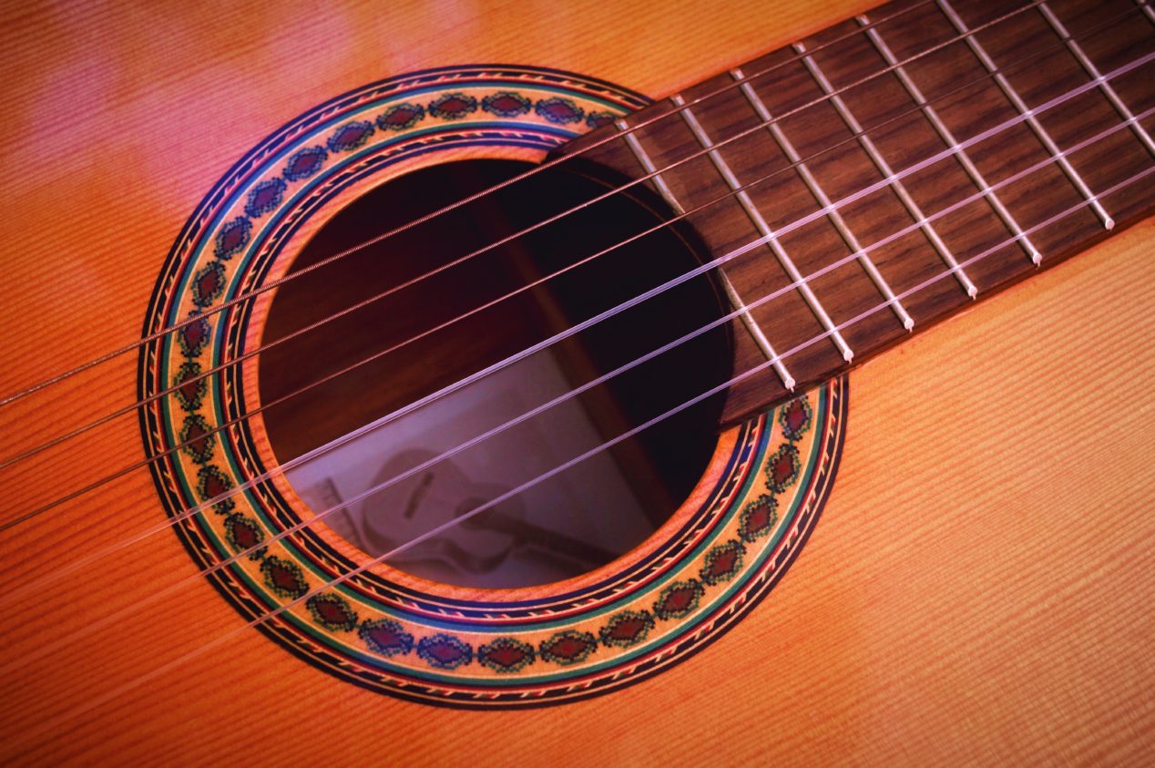 Close up photo of a classical guitar's sound hole.