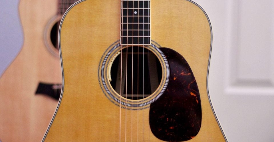 Close-up photo of a modern Martin guitar in a room.