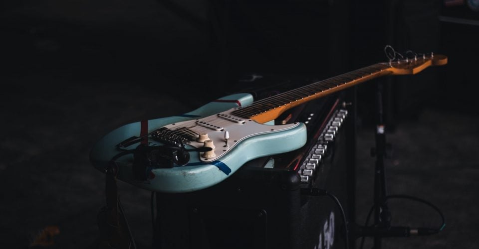 Photo of a light blue Stratocaster sitting on an amp.